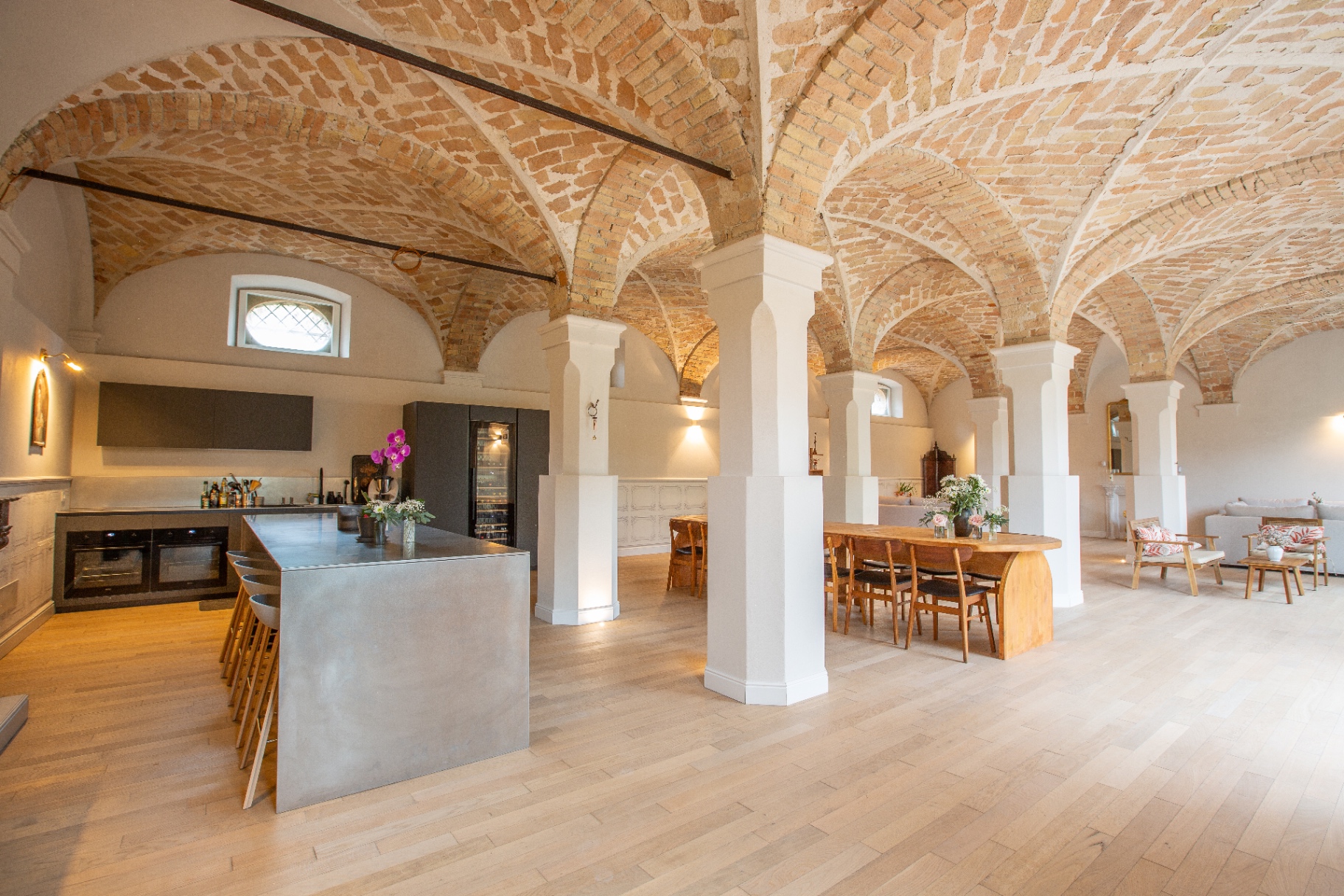 Restored vaulted brick salone with bespoke kitchen island in a Monferrato property