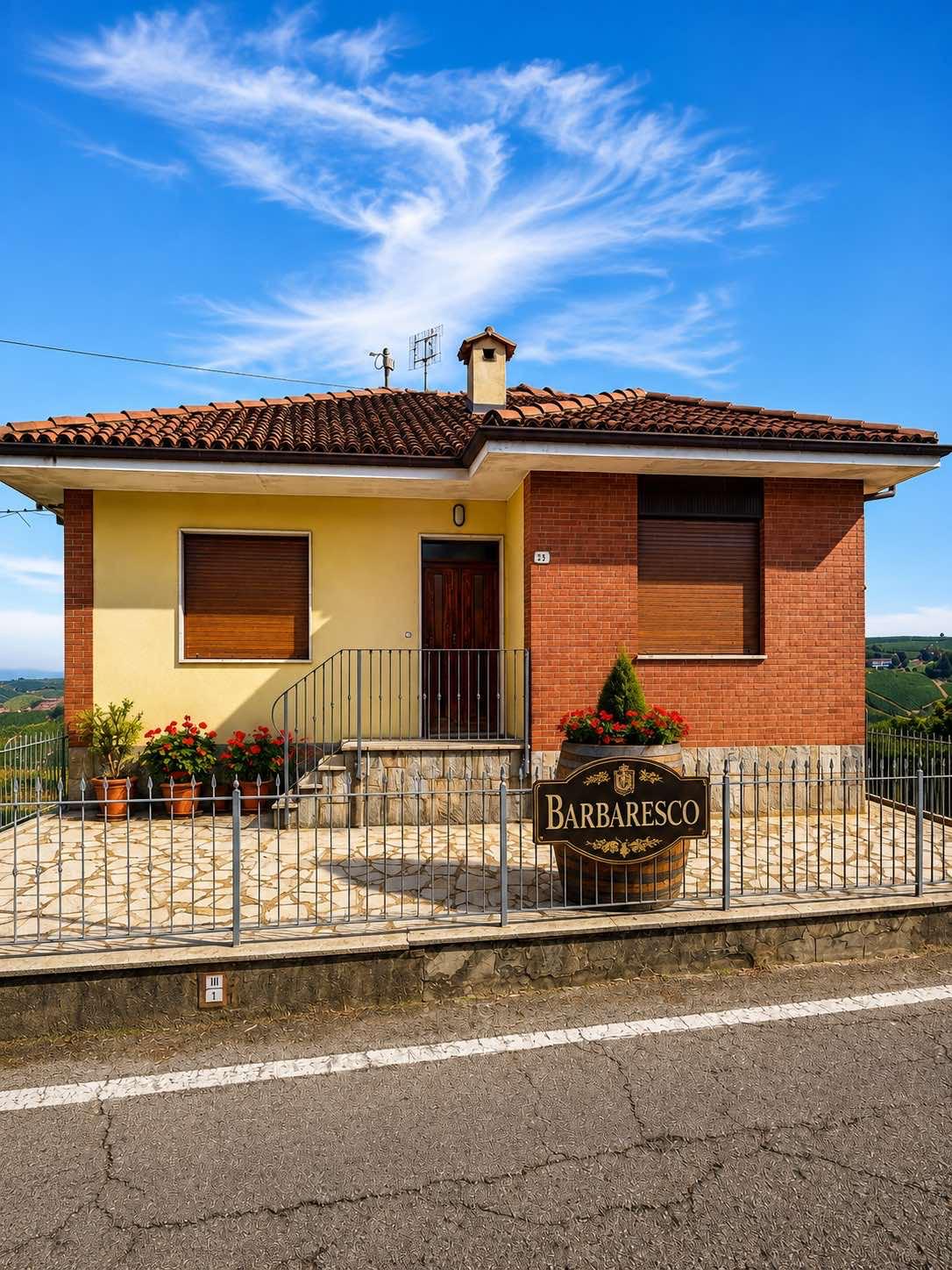 Entrance terrace with the Barbaresco barrel sign and stone paving