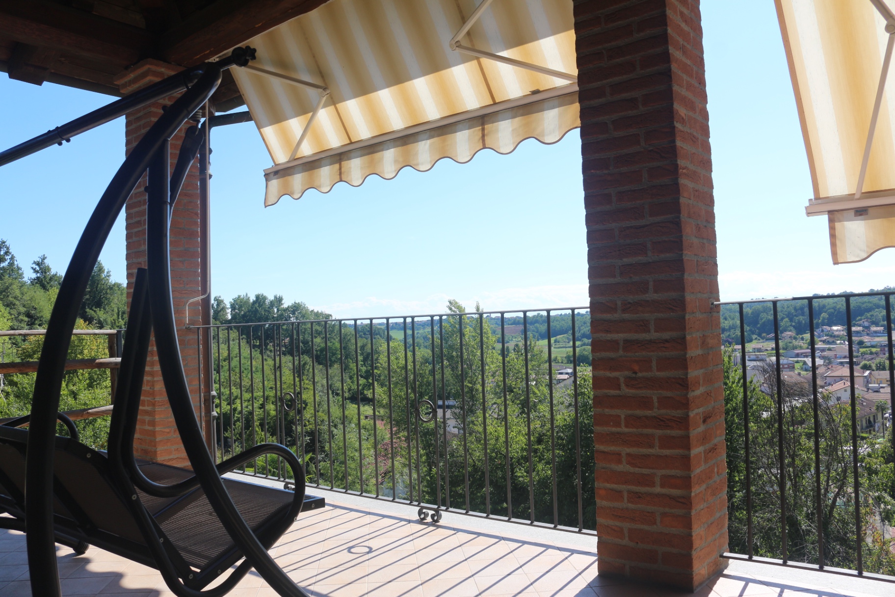 Covered terrace at the Castelnuovo property with hill views