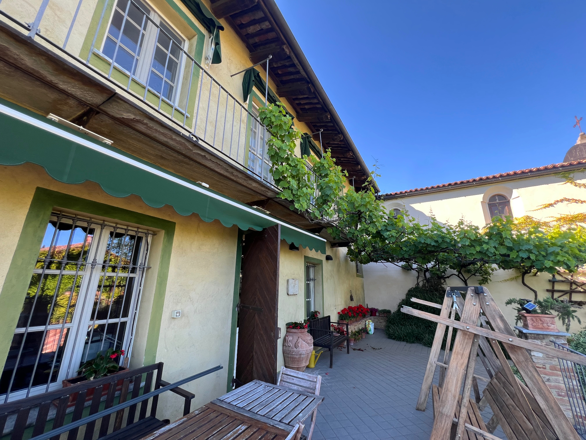 Interior courtyard of the Cocconato property with vine-covered pergola