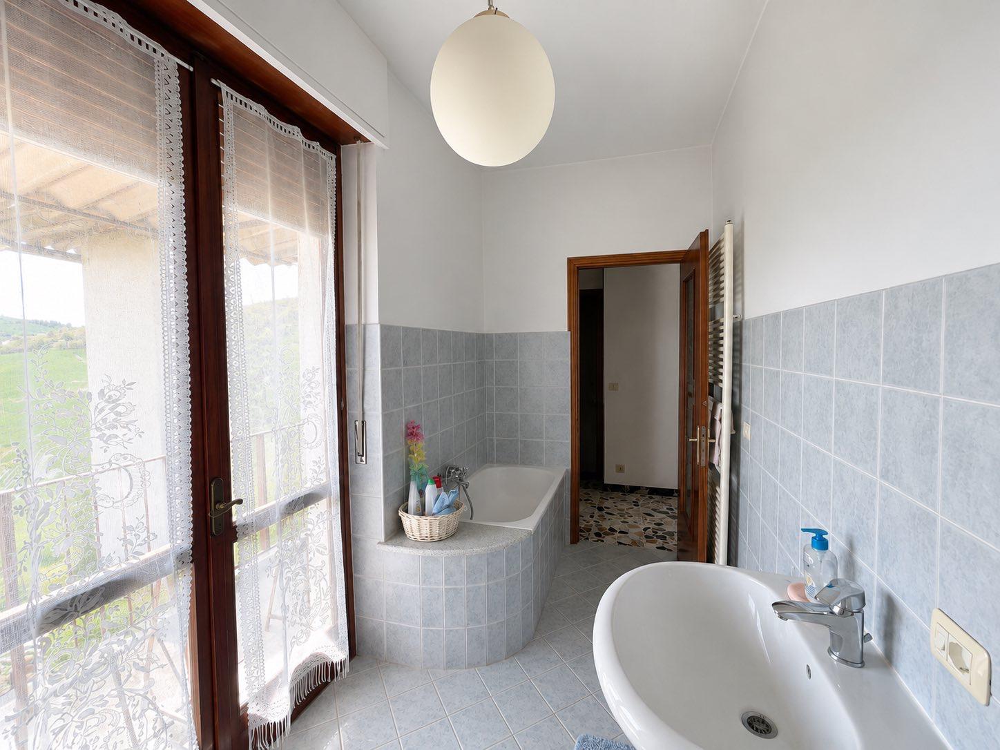 Bathroom with bathtub and hillside view